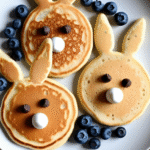 Bunny-shaped pancakes with chocolate chip eyes and blueberries for Easter breakfast