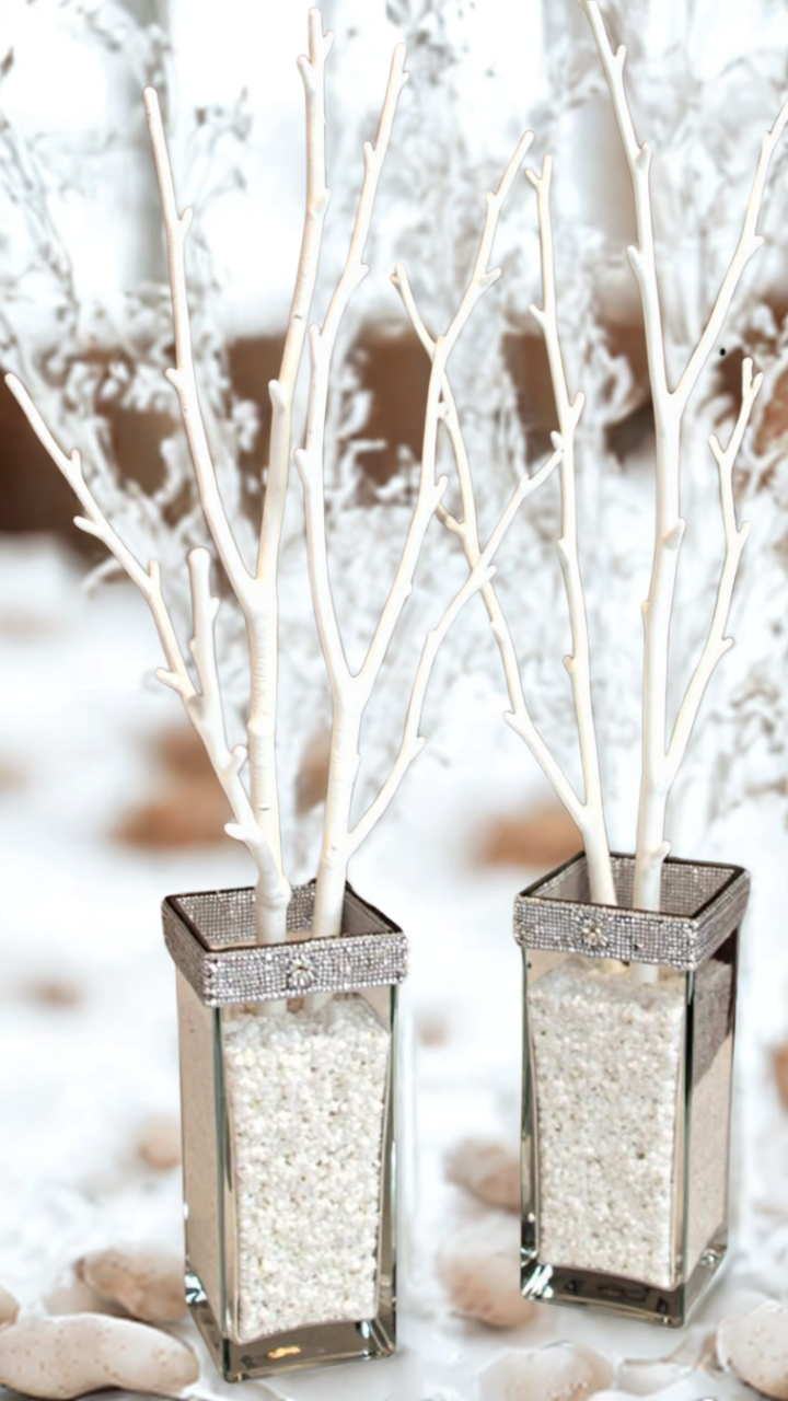 Tall mirrored vases filled with pearl beads and white winter branches, accented with rhinestone trim, perfect for elegant winter wedding decor.