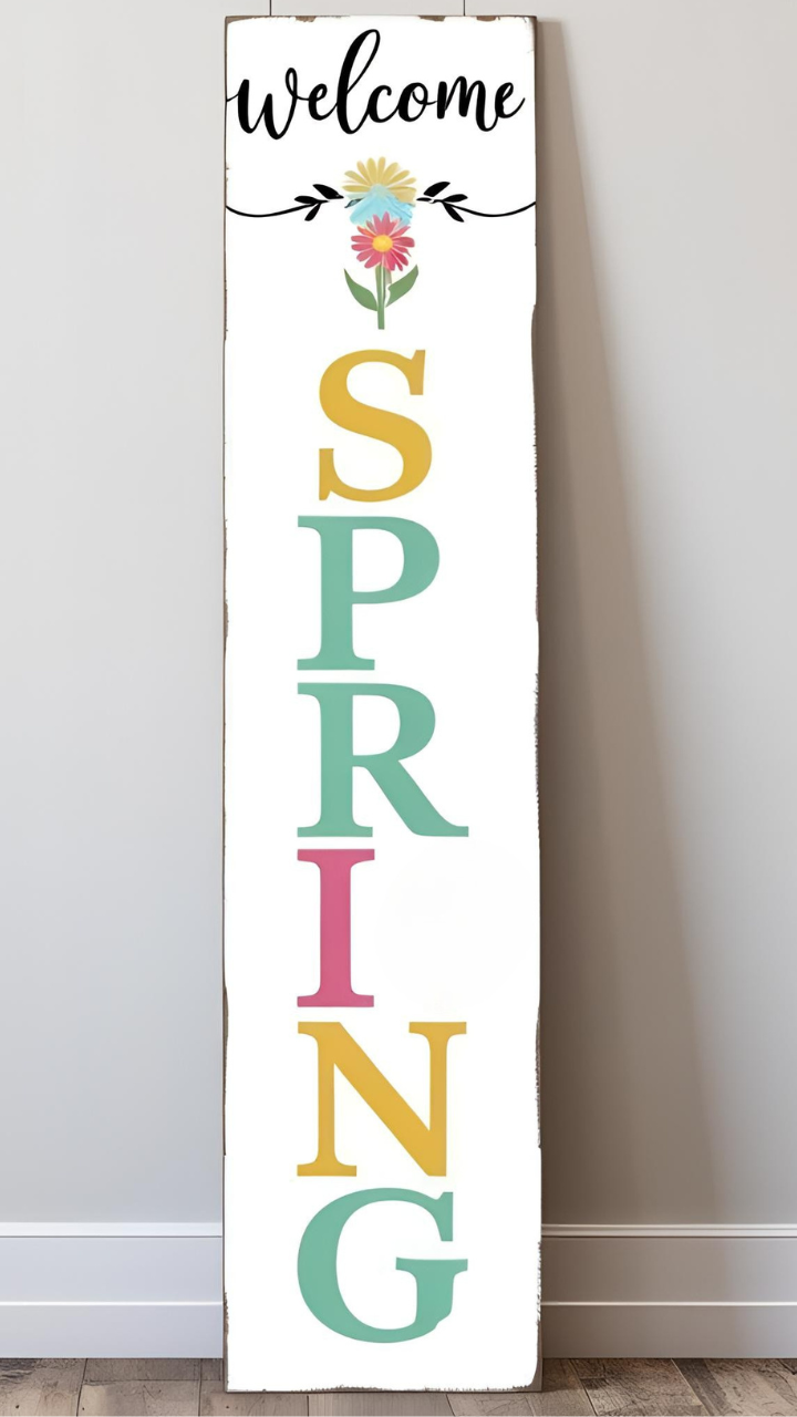 A vertical wooden sign with 'Welcome Spring' in colorful letters and a floral design at the top.